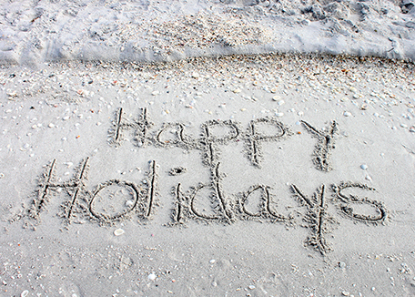 Happy holidays written in sand