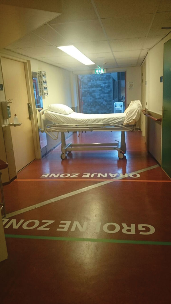 Entrance of isolation unit with demarcated zones, Major Incident Hospital, University Medical Centre of Utrecht, the Netherlands, 2014. Markings on the floor indicate a safe zone and potentially contaminated zones and delineate doffing zones (where potentially contaminated clothing and gear are removed) for ambulance and disinfection personnel.