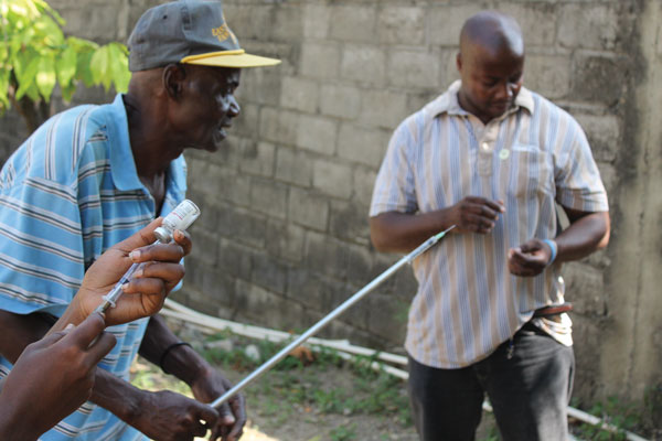 A team consisting of workers from the US Centers of Disease Control and Prevention; the Pan American Health Organization; Haiti’s Ministry of Agriculture, Natural Resources and Rural Development; and Christian Veterinary Mission trained 11 veterinary professionals on principles of animal rabies surveillance. Here, trainees gain experience drawing up sedative medications into a pole syringe, which is used to sedate suspected rabid animals from a safe distance. (Photograph courtesy of R.M. Wallace