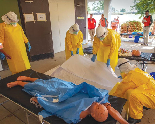 Constructed mock Ebola Treatment Unit used during the Centers for Disease Control and Prevention Ebola Safety Training Course, held at the US Federal Emergency Management Agency Center for Domestic Preparedness in Anniston, Alabama, USA, 2014–2015. Trainees prepare to place a simulated deceased patient into a body bag.