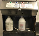Device calibrated to dilute Cell Block 64 solution and other cleaners to correct concentrations. Device pictured shows dangling tubing touching the machine surface, a possible route of contamination in outbreak of invasive Serratia marcescens infections at prison A, California, USA, January 2020–March 2023.