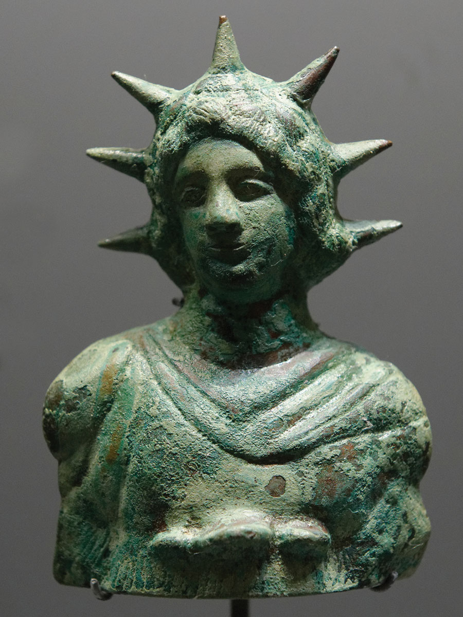Bust of Helios, radiate (seven rays), with long hair, wearing a chlamys, a short cloak worn by men in ancient Greece. 1st century CE. Public domain image by Marie-Lan Nguyen. Holding institution: Louvre Museum, Paris, France.  