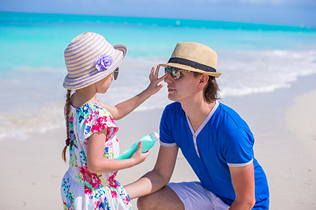 Child putting on sunscreen