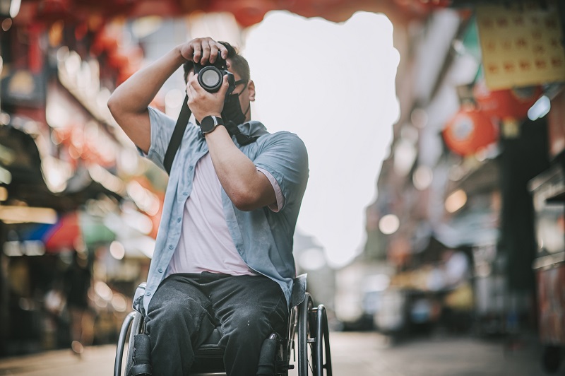 traveler in wheelchair taking photo