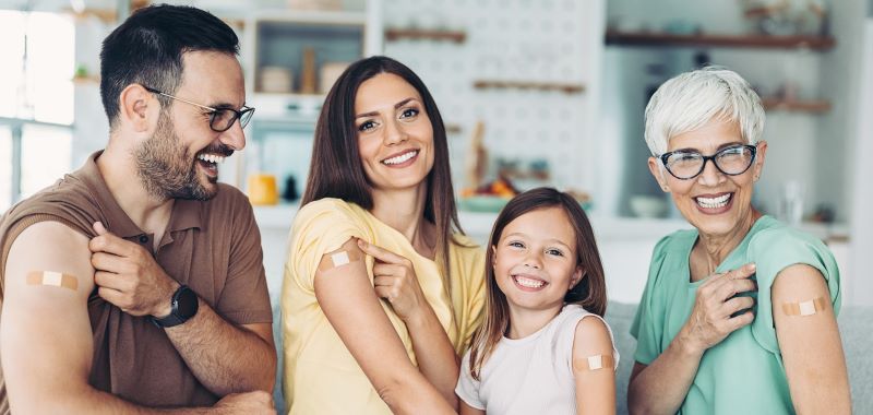 family showing vaccine band-aids